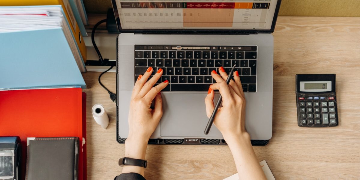 création d'entreprise : entrepreneur planifiant le lancement de son entreprise avec des documents et un ordinateur